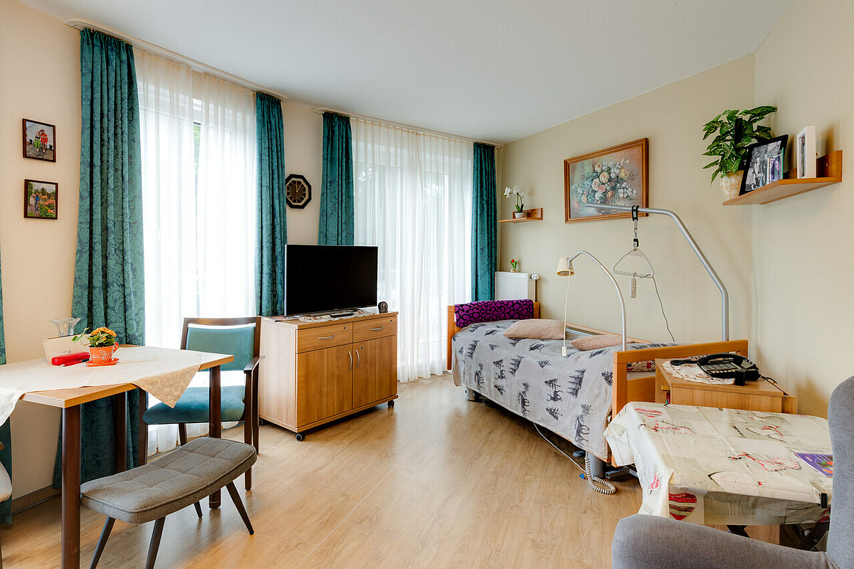 Einzelzimmer mit zwei Sitzecken und TV