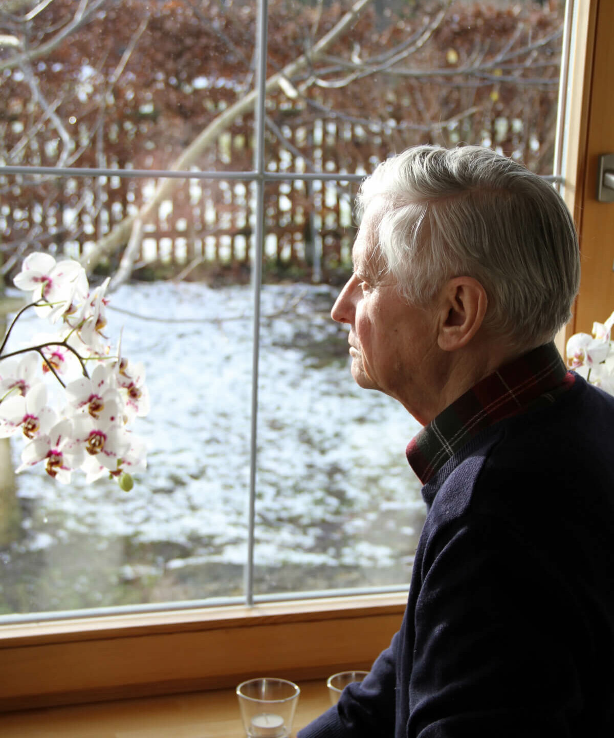 Senior schaut aus dem Fenster