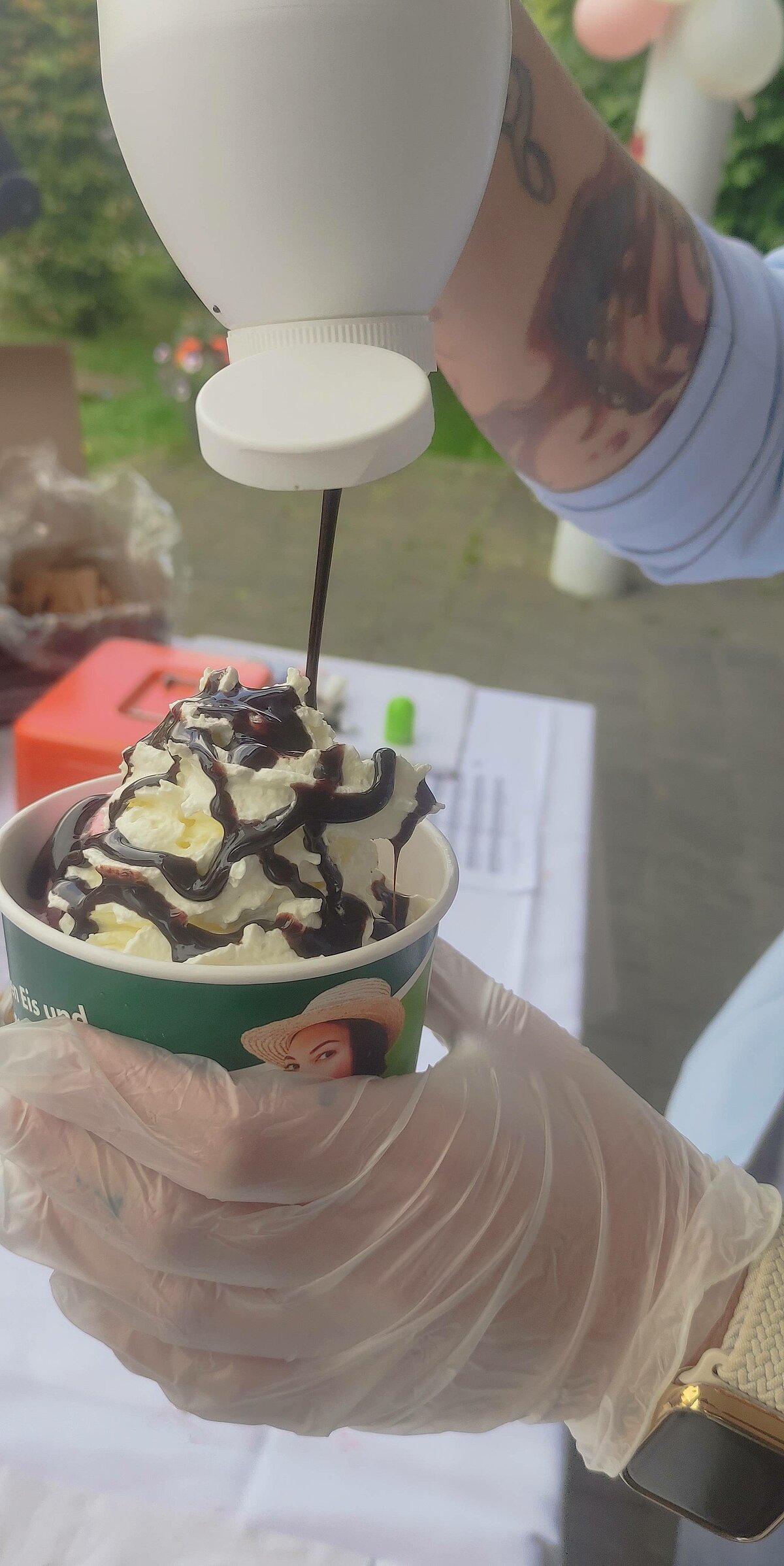 Schokoladensoße wird auf einen Eisbecher gemacht