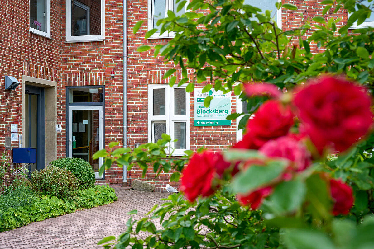 Eingang des Pflegeheims mit Blumen im Vordergrund