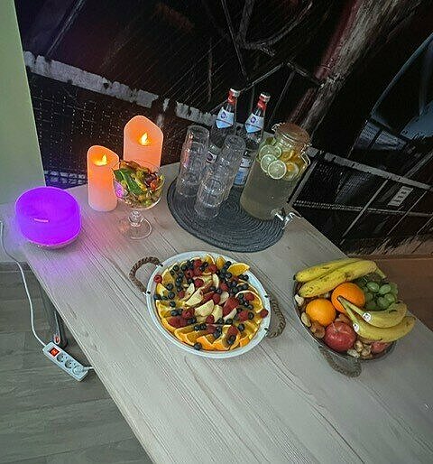 Tisch mit Getränken und Obst sowie einigen elektrischen Kerzen