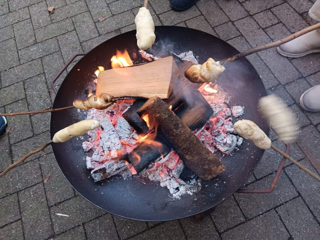 An Feuerschale wird Stockbrot gemacht