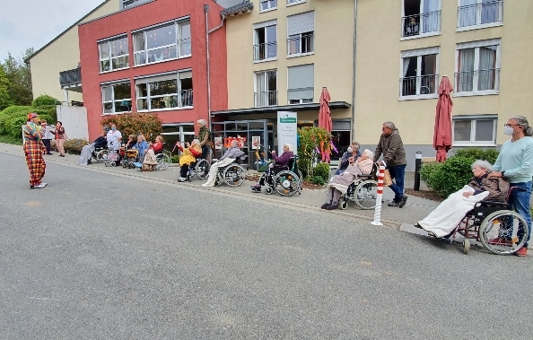 Ralle, der singende Clown, unterhält Senioren vor der Alloheim Senioren-Residenz Essenheim
